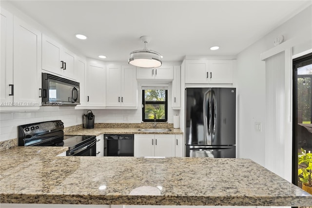 kitchen with sink, black appliances, white cabinets, light stone countertops, and tasteful backsplash