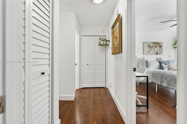 hall with dark hardwood / wood-style flooring and a textured ceiling