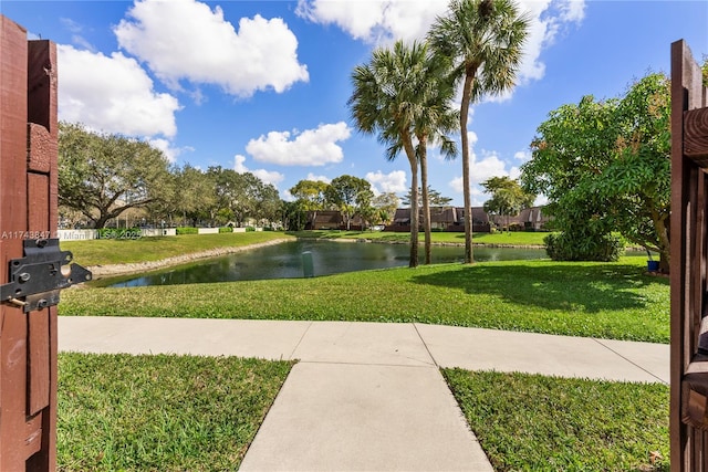 surrounding community featuring a water view and a lawn