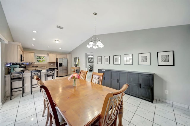 dining room with lofted ceiling and an inviting chandelier