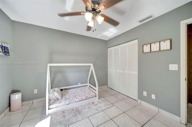 bedroom featuring light tile patterned floors, a closet, and ceiling fan