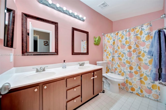 bathroom featuring tile patterned flooring, vanity, walk in shower, and toilet