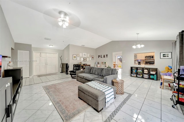 living room featuring lofted ceiling and ceiling fan with notable chandelier