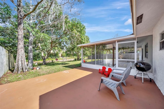 view of patio with a sunroom and a grill