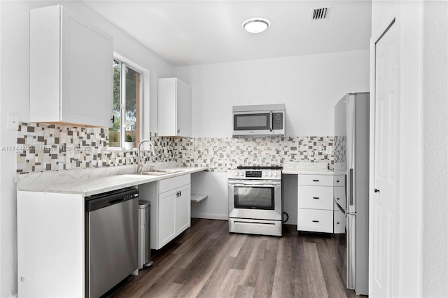 kitchen featuring appliances with stainless steel finishes, tasteful backsplash, sink, white cabinets, and dark hardwood / wood-style flooring