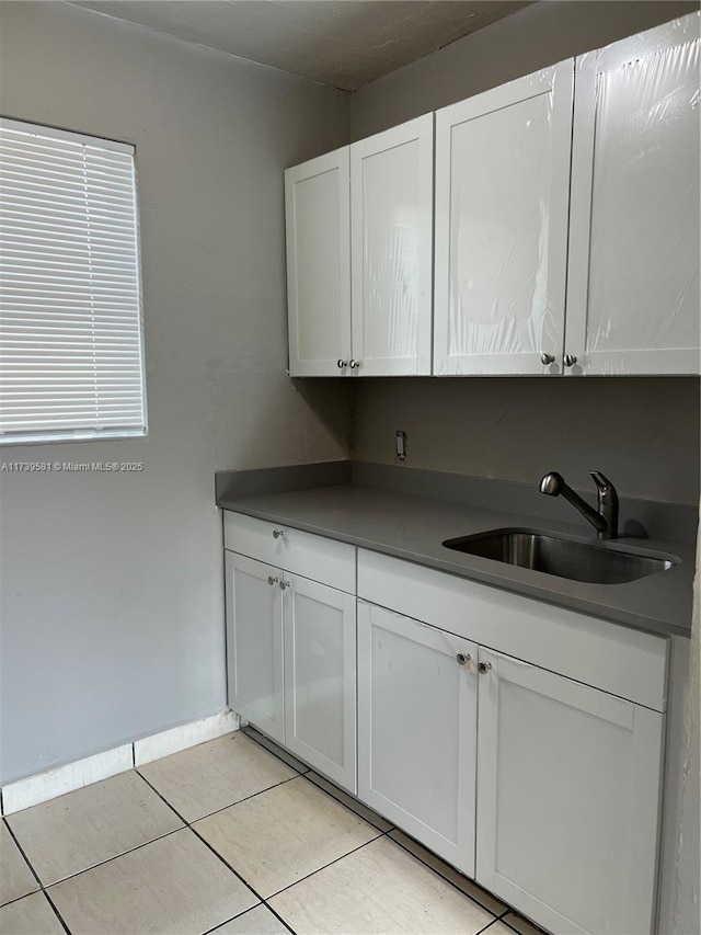 kitchen featuring white cabinetry, sink, and light tile patterned floors