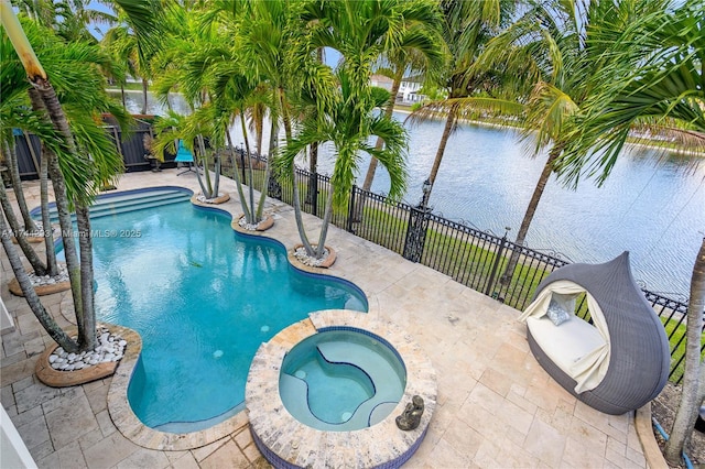 view of pool featuring an in ground hot tub, a water view, and a patio