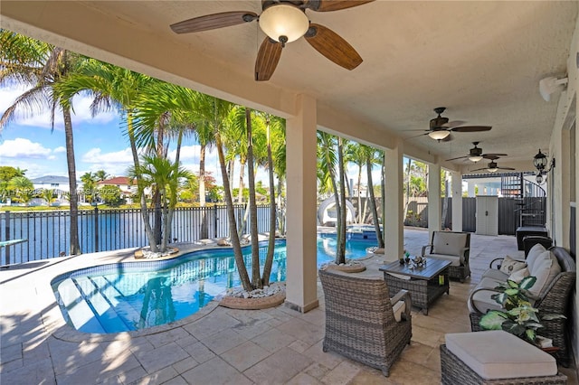 view of pool featuring a patio, ceiling fan, and a water view