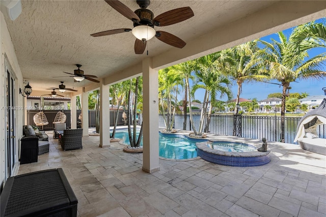 view of patio with a water view and a swimming pool with hot tub