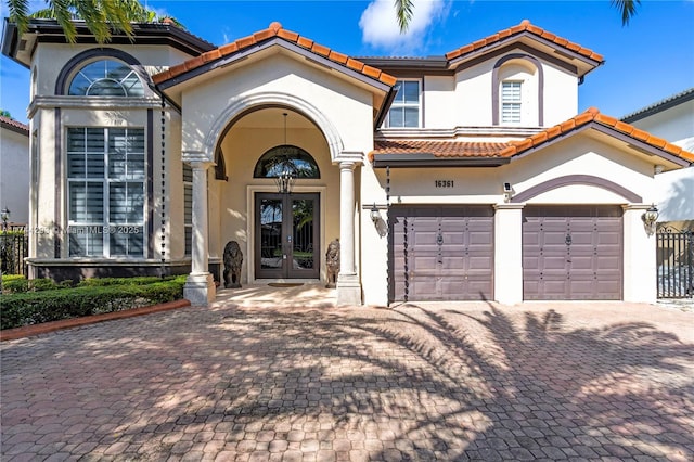 mediterranean / spanish home featuring a garage and french doors