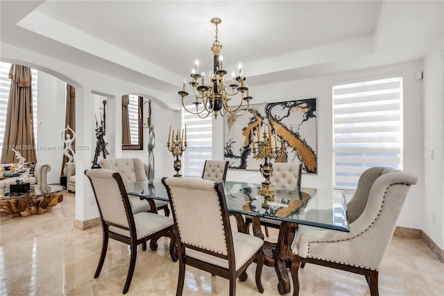 dining room featuring a chandelier and a raised ceiling