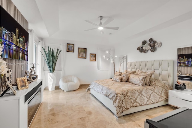 bedroom with a raised ceiling and ceiling fan