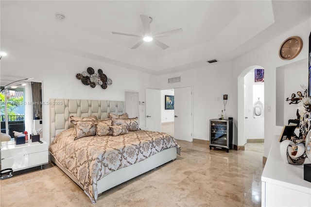 bedroom featuring a raised ceiling, wine cooler, and ceiling fan