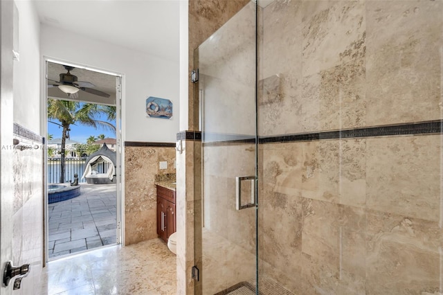 bathroom with toilet, tile walls, ceiling fan, and walk in shower