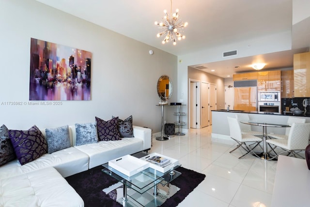 living room with light tile patterned flooring, sink, and a notable chandelier