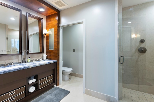 bathroom featuring vanity, toilet, tile patterned flooring, and a shower with door