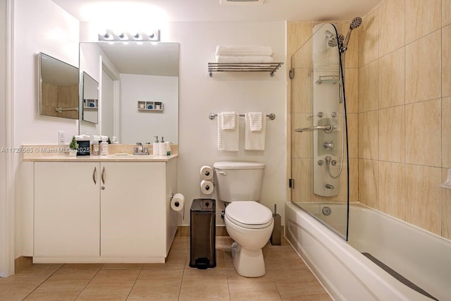 full bathroom featuring tiled shower / bath, vanity, tile patterned floors, and toilet