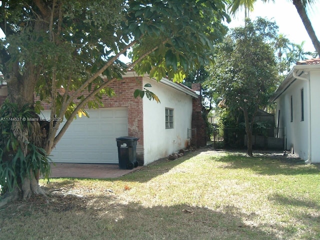 view of side of property with a garage and a lawn