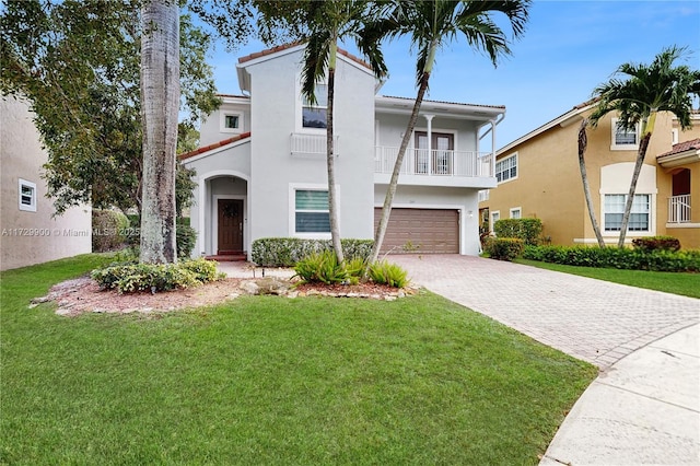 mediterranean / spanish home with a garage, a front lawn, decorative driveway, and a balcony