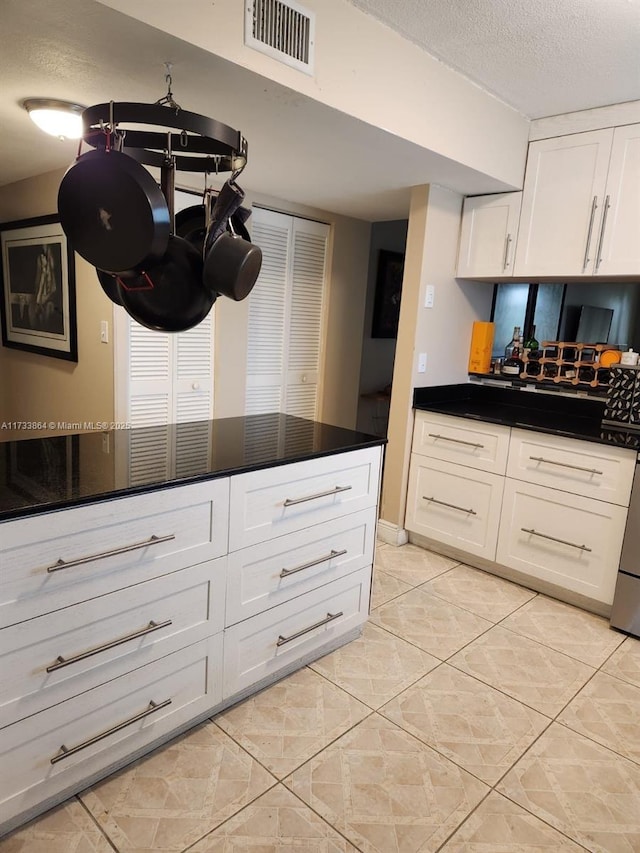 kitchen featuring white cabinets and a textured ceiling