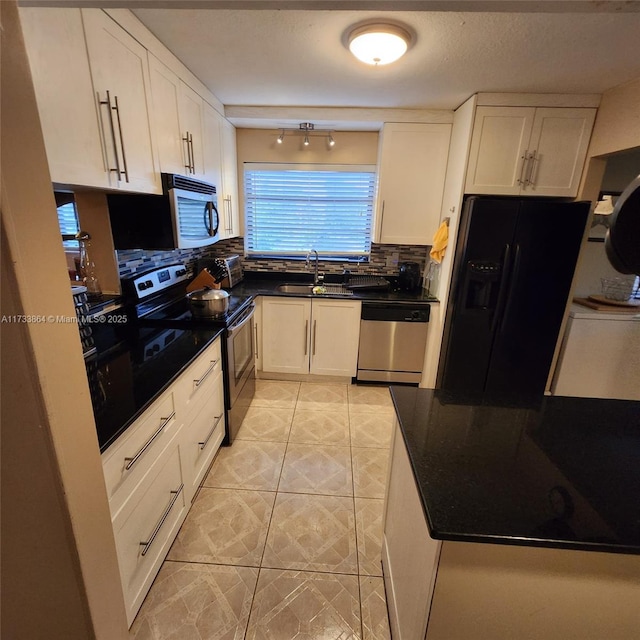 kitchen with light tile patterned flooring, sink, tasteful backsplash, appliances with stainless steel finishes, and white cabinets