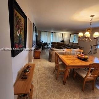 dining area featuring tile patterned floors and an inviting chandelier