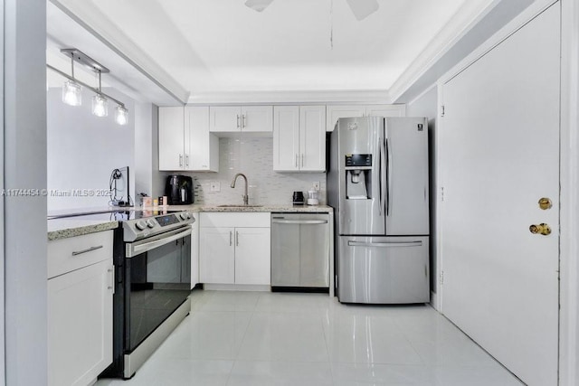 kitchen featuring sink, white cabinetry, hanging light fixtures, stainless steel appliances, and light stone countertops