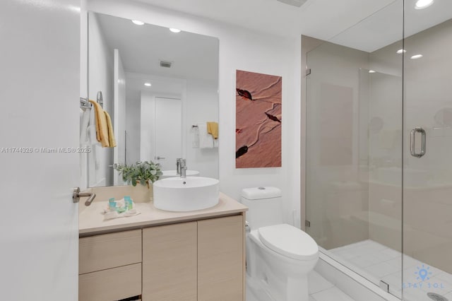 bathroom with vanity, toilet, and a shower with door