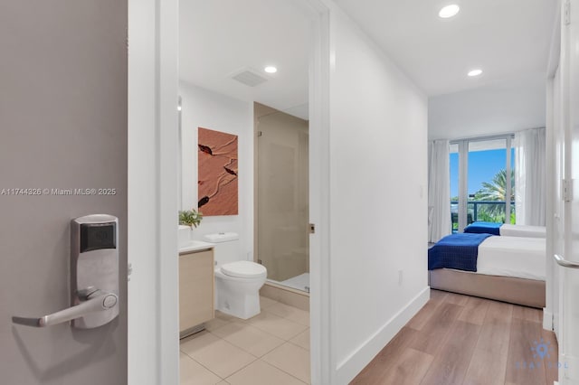 bathroom with vanity, toilet, a shower with door, and hardwood / wood-style floors