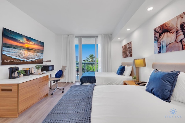 bedroom featuring floor to ceiling windows, access to exterior, and light hardwood / wood-style flooring