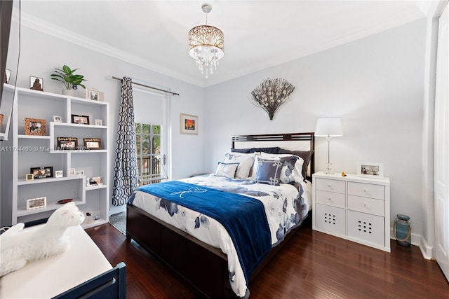 bedroom featuring dark hardwood / wood-style flooring, access to outside, ornamental molding, and an inviting chandelier