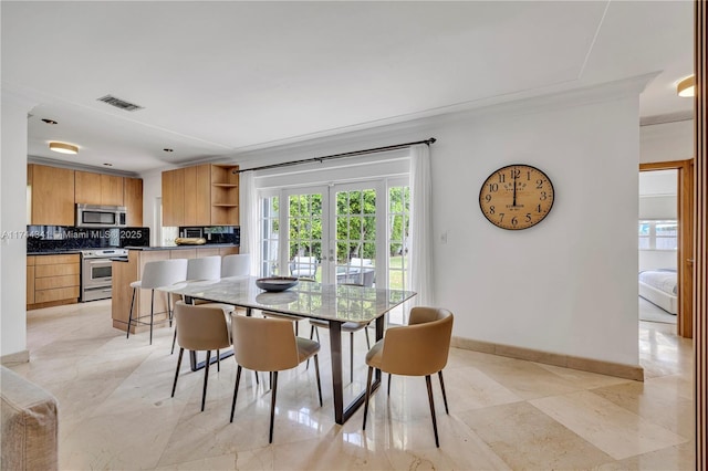 dining area featuring french doors and crown molding