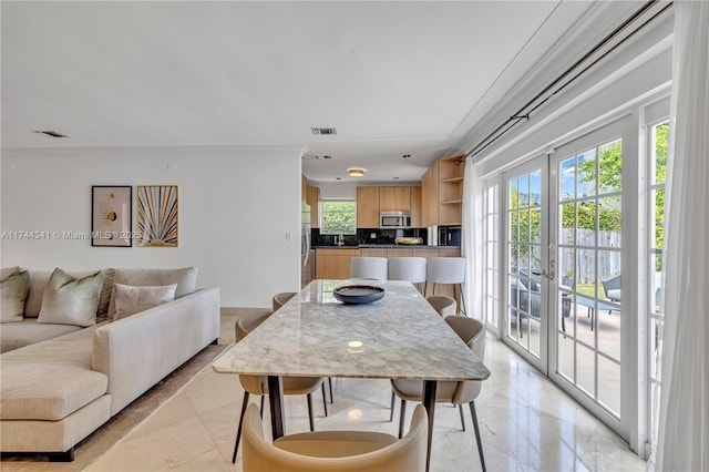 dining space with sink and french doors