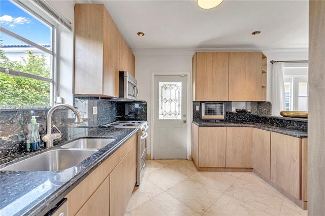 kitchen featuring light brown cabinetry, sink, stainless steel appliances, and dark stone counters