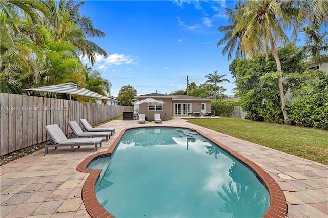 view of swimming pool featuring a patio and a yard