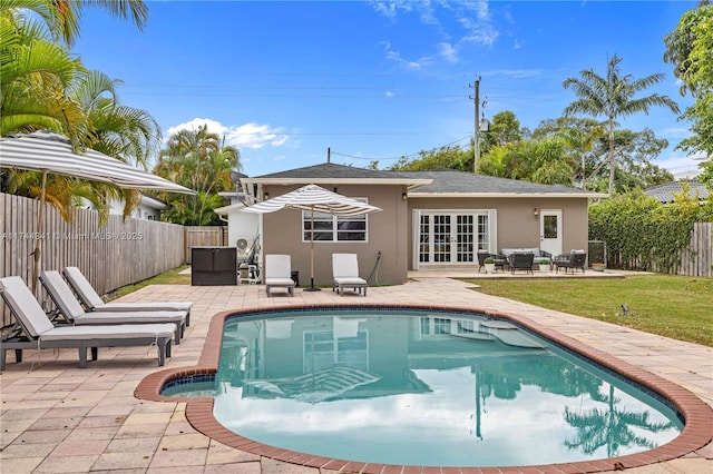 back of property with french doors, a fenced in pool, and a patio