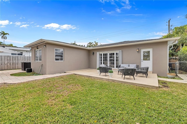 back of property with french doors, a yard, outdoor lounge area, and a patio area