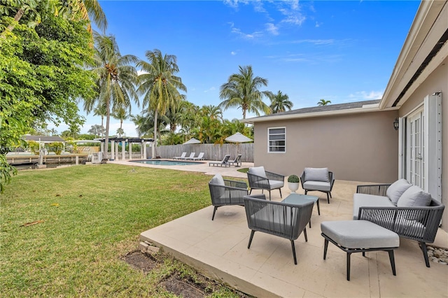 view of yard with a fenced in pool, outdoor lounge area, a patio, and french doors