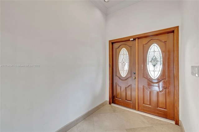 tiled foyer featuring ornamental molding