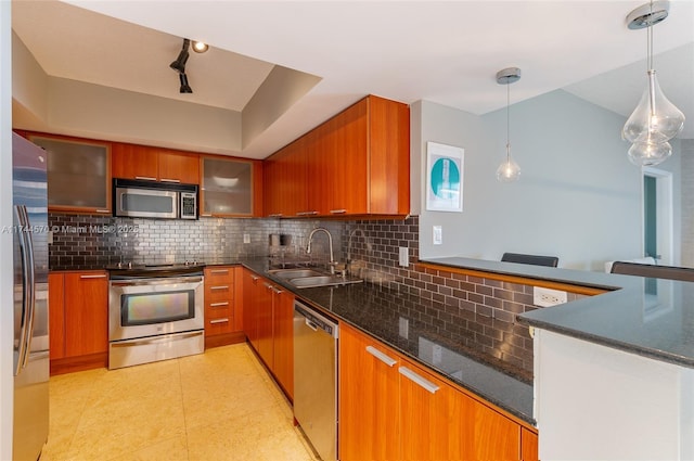 kitchen featuring pendant lighting, appliances with stainless steel finishes, sink, and decorative backsplash