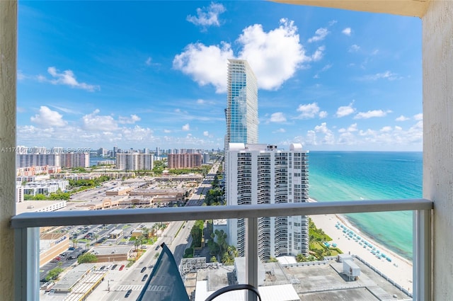 balcony with a water view and a view of the beach