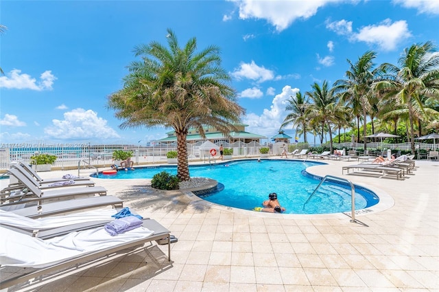 view of swimming pool with a water view and a patio area