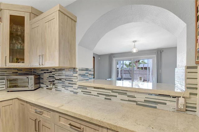 kitchen with light brown cabinetry and decorative backsplash