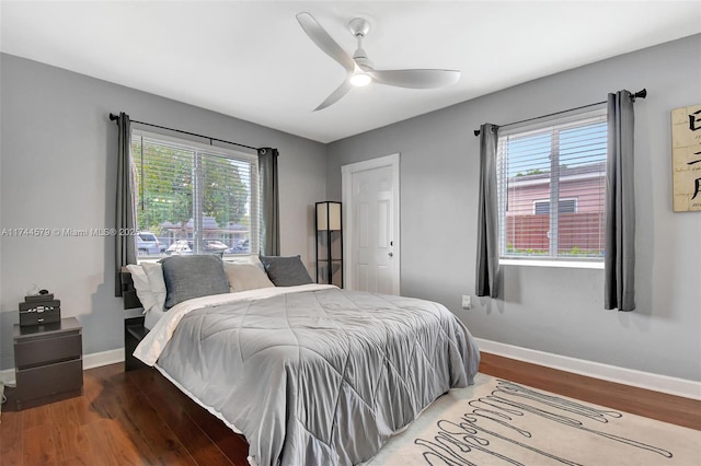 bedroom with multiple windows, wood-type flooring, and ceiling fan