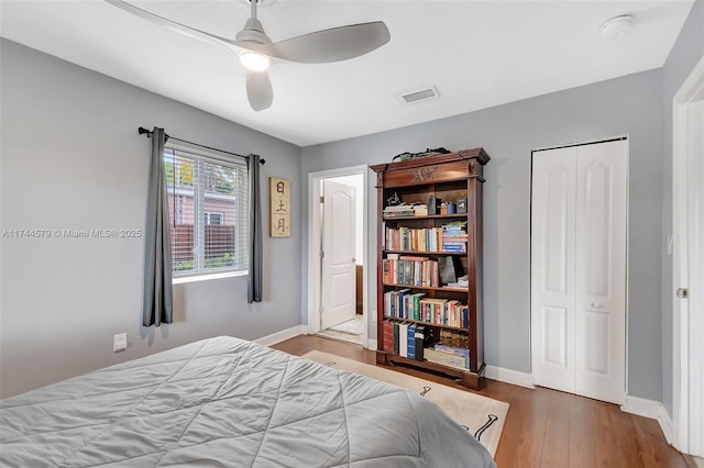 bedroom with hardwood / wood-style flooring, ceiling fan, and a closet