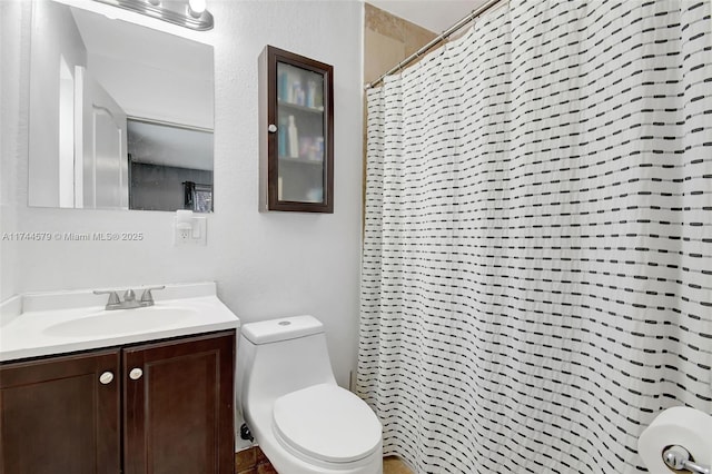 bathroom featuring vanity, toilet, and curtained shower