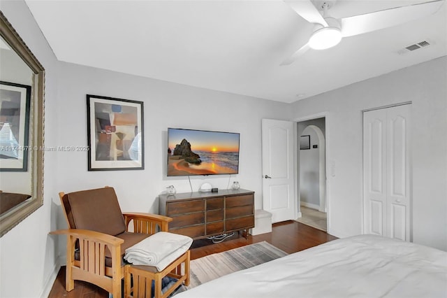 bedroom featuring ceiling fan, dark hardwood / wood-style flooring, and a closet