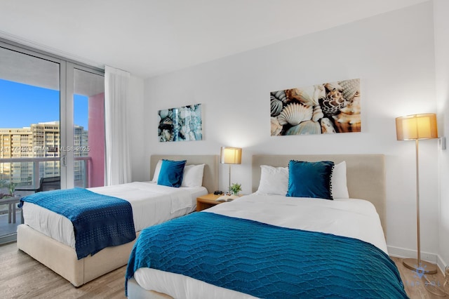 bedroom featuring light hardwood / wood-style flooring and floor to ceiling windows