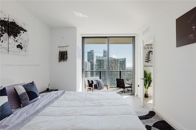 bedroom with floor to ceiling windows, wood-type flooring, and access to outside