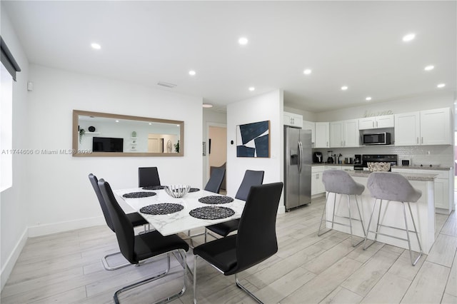 dining space with visible vents, light wood-style flooring, recessed lighting, and baseboards